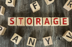 light wooden blocks on darker wooden pallets spelling out "storage" in red letters