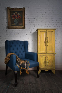 Vintage blue armchair, yellow cupboard and framed painting that should have climate control storage