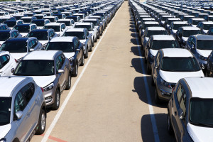 Rows of new cars in car storage covered in protective white sheet