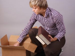 young man moving and packing things and books to move to a self storage