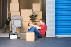 man taking break from packing up his storage unit