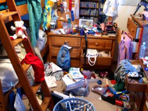 Teenager's messy bedroom, with clothes and other things strewn about.
